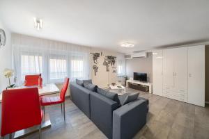salon z kanapą i stołem w obiekcie Centroom Pécs Apartman w mieście Pecz