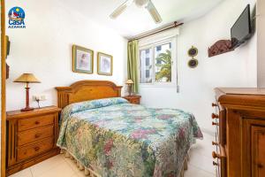 a bedroom with a bed and a dresser and a window at Apartamentos La Noria Casa Azahar in Alcossebre