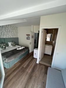 a hotel room with a bed and a bathroom at Junqueira76 Guesthouse in Póvoa de Varzim