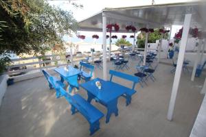 a group of blue tables and chairs on a patio at Batis Breeze Suites in (( Filaréton ))