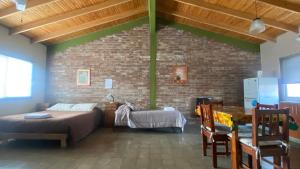 1 dormitorio con 2 camas y pared de ladrillo en Monoambiente Luminoso y Tranquilo en Mendoza
