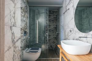 ein Badezimmer mit einer Dusche, einem Waschbecken und einer Badewanne in der Unterkunft Isla Villas & Suites in Balíon