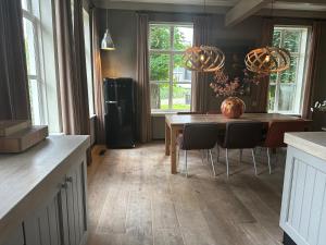 a kitchen with a wooden table and a dining room at The Butchersfarm in Ter Aar