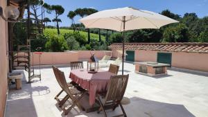 a patio with a table and an umbrella at Frascati Country House in Grottaferrata