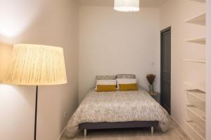 a bedroom with a bed and a lamp and shelves at T2 avec terrasse in Dax