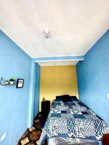 a bedroom with a bed in a blue wall at Nicolas House #2 with Lake Atitlán View in San Pedro La Laguna