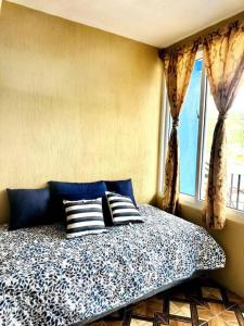 a bedroom with a bed with pillows and a window at Nicolas House #2 with Lake Atitlán View in San Pedro La Laguna