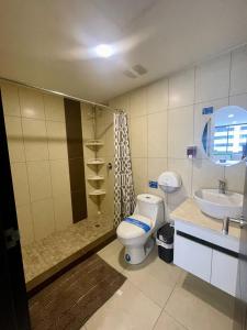 a bathroom with a toilet and a shower and a sink at Santa Ana Suite - Bellini 2 in Guayaquil