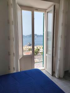 a bedroom with a blue bed and a view of the ocean at VisitPonza - Olimpo in Ponza