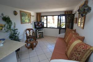 a living room with a couch and a tv at Castillo Lanzarote Villa 3 - Sleep in a Volcanic Cave in La Asomada