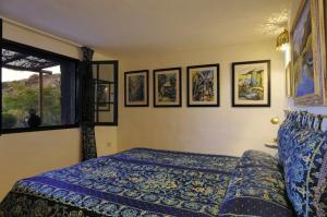 Un dormitorio con una cama y cuadros en la pared. en Castillo Lanzarote Villa Bailey - Luxury Villa - Pet friendly with heated Pool, en La Asomada 53 fotos más