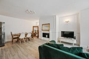 a living room with a couch and a dining room at Stunning 3 bed 2 bathroom BASEMENT flat in earls court, London in London
