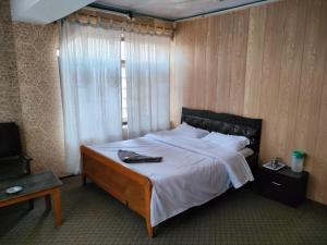um quarto com uma cama grande e uma janela em HOTEL REGENCY em Srinagar