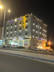 ein großes Hotelgebäude mit davor geparkt in der Unterkunft هدوء الليالي للأجنحة الفندقية in Chamis Muschait