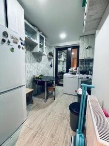 eine Küche mit einem weißen Kühlschrank und einem Tisch in der Unterkunft happy home in Bordschomi