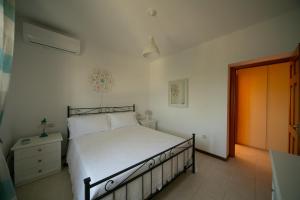 マルティナ・フランカにあるDimora Beatriceのベッドルーム1室(白いシーツとオレンジのドア付)