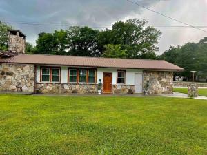 a small stone house with a grass yard at small rental for couple getaway in Dalton