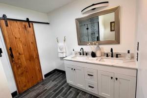 a bathroom with two sinks and a wooden door at small rental for couple getaway in Dalton