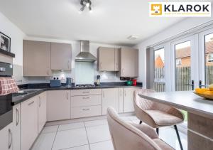 uma cozinha com armários brancos e uma mesa com cadeiras em Four Bedroom Semi Detached House By Klarok Accommodation Peterborough With Free Parking & Garden em Peterborough
