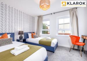 a bedroom with two beds and a desk and a chair at Four Bedroom Semi Detached House By Klarok Accommodation Peterborough With Free Parking & Garden in Peterborough