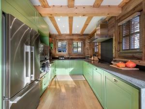 a kitchen with green cabinets and a wooden ceiling at Chalet avec jacuzzi, proche des pistes, pour 10 personnes - FR-1-570-20 in Saint-Martin-de-Belleville +9 photos