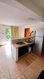 a kitchen with a stove and a refrigerator at Posada Villa Mayo Apartamento Familiar a 5 Min de Playa Parguito in Paraguachi