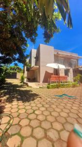 eine Terrasse mit Stühlen und ein Gebäude im Hintergrund in der Unterkunft Posada Villa Mayo Apartamento Familiar a 5 Min de Playa Parguito in Paraguchi