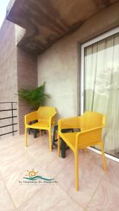 two yellow tables and chairs on a patio at Posada Villa Mayo Apartamento Familiar a 5 Min de Playa Parguito in Paraguchi