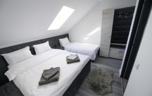 two beds in a small room with towels on them at Pensiunea Lor in Sighetu Marmaţiei +13 photos