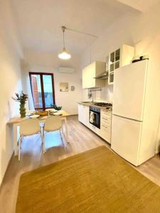 cocina con mesa y nevera blanca en Appartamento vicino al mare- IL GIACINTO, en Civitanova Marche