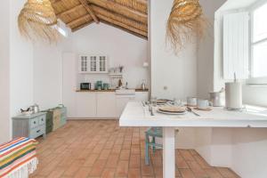 uma cozinha com um balcão branco e uma mesa em Casa Formosa - Serena Tradição em Santa Luzia