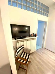 sala de estar con TV y silla en Appartamento vicino al mare- IL GIACINTO, en Civitanova Marche