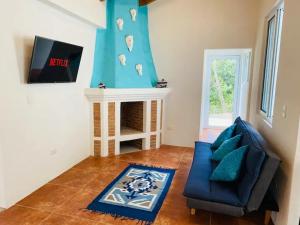 a living room with a blue couch and a fireplace at Villa Palopo in Santa Catarina Palopó