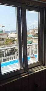 a window with a view of a pool from a building at Θέρετρο Γαλάζιου Ουρανού in Athens