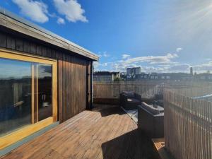 愛丁堡的住宿－Rooftop Retreat，大楼顶部的木制甲板上配有沙发