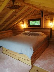 1 cama en una cabaña de madera con ventana en YEŞİL BAHÇE EVLERİ 