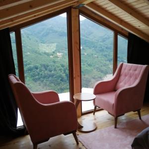 two chairs and a table in a room with a view at YEŞİL BAHÇE EVLERİ 