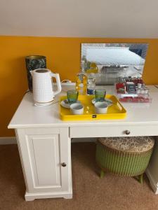 a white desk with a yellow tray with dishes on it at ByTheSea in Malahide