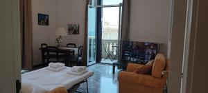 een woonkamer met een bank en een televisie bij Adua Exclusive Suite in Bari