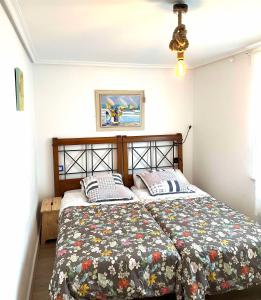 a bedroom with two beds and a picture on the wall at CAMELIA Casina Rural in Albuerne