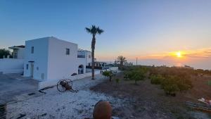 Un uomo sta guardando il tramonto da una casa di Nireas Villa a Paphos