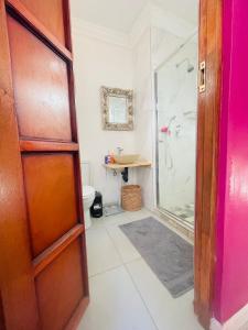 a bathroom with a shower and a glass door at Bird Song in Roodepoort