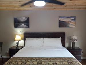 a bedroom with a bed with two lamps and two pictures at Carter Lodge - On The River in Chimney Rock
