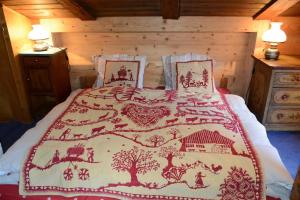 a bed with a red and white blanket on it at Le Vieux Chalet in Gstaad
