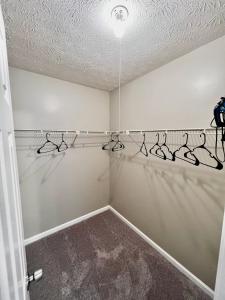a walk in closet with hangers on the wall at Ecstatic Town Home In Stone Mountain in Stone Mountain
