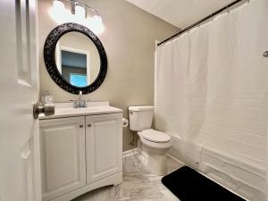 a bathroom with a toilet and a sink and a mirror at Ecstatic Town Home In Stone Mountain in Stone Mountain