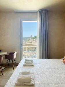 a bedroom with a bed and a large window at La casa di Irene - Suites con vista in Ragusa