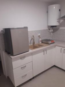 a kitchen with a sink and a tv on a counter at STUDIO 25 in Vaslui