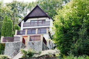 ein großes weißes Haus mit einem Balkon und Bäumen in der Unterkunft Traumhaftes Ferienhaus im Buchengebirge in Bükkszentkereszt