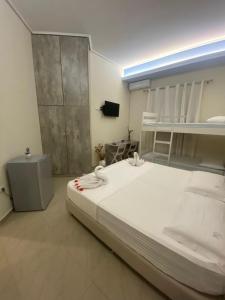 a large white bed in a room with a bunk bed at FA_HOLIDAYS in Vlorë